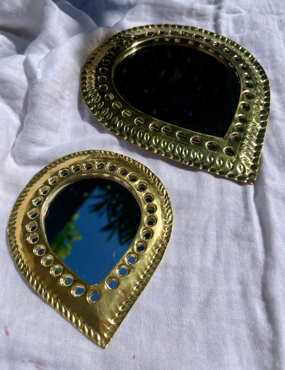 Détail des miroirs goutte en laiton doré ciselé